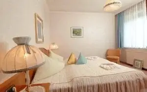 Schlafzimmer der Ferienwohnung Eva A mit Doppelbett, Wandleuchten und Fenster