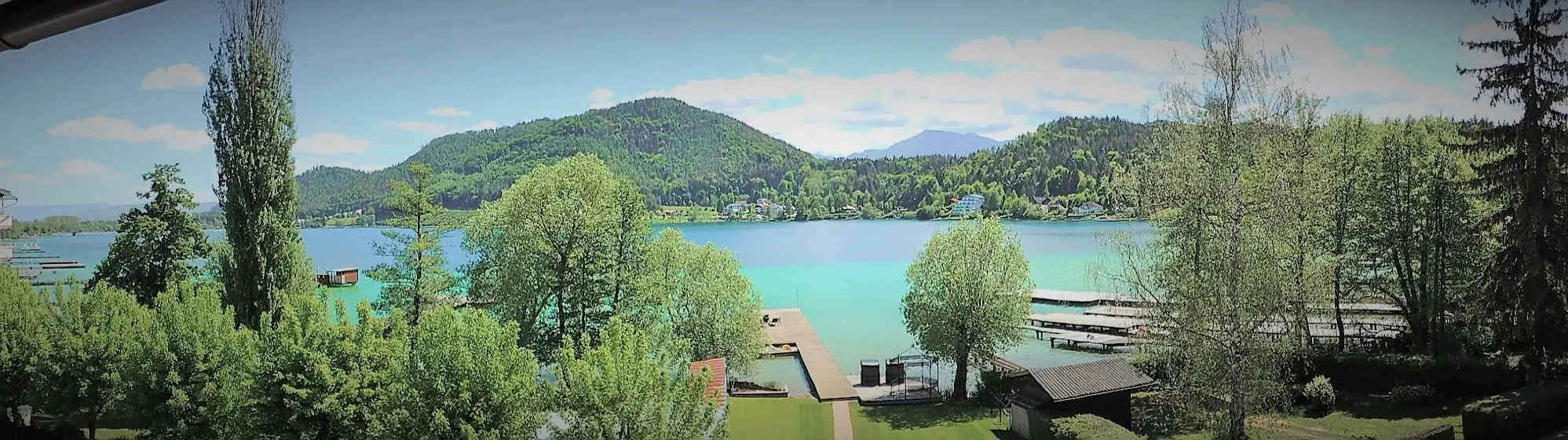 Panoramablick über den Ufergarten, die Badestege und den Klopeinersee